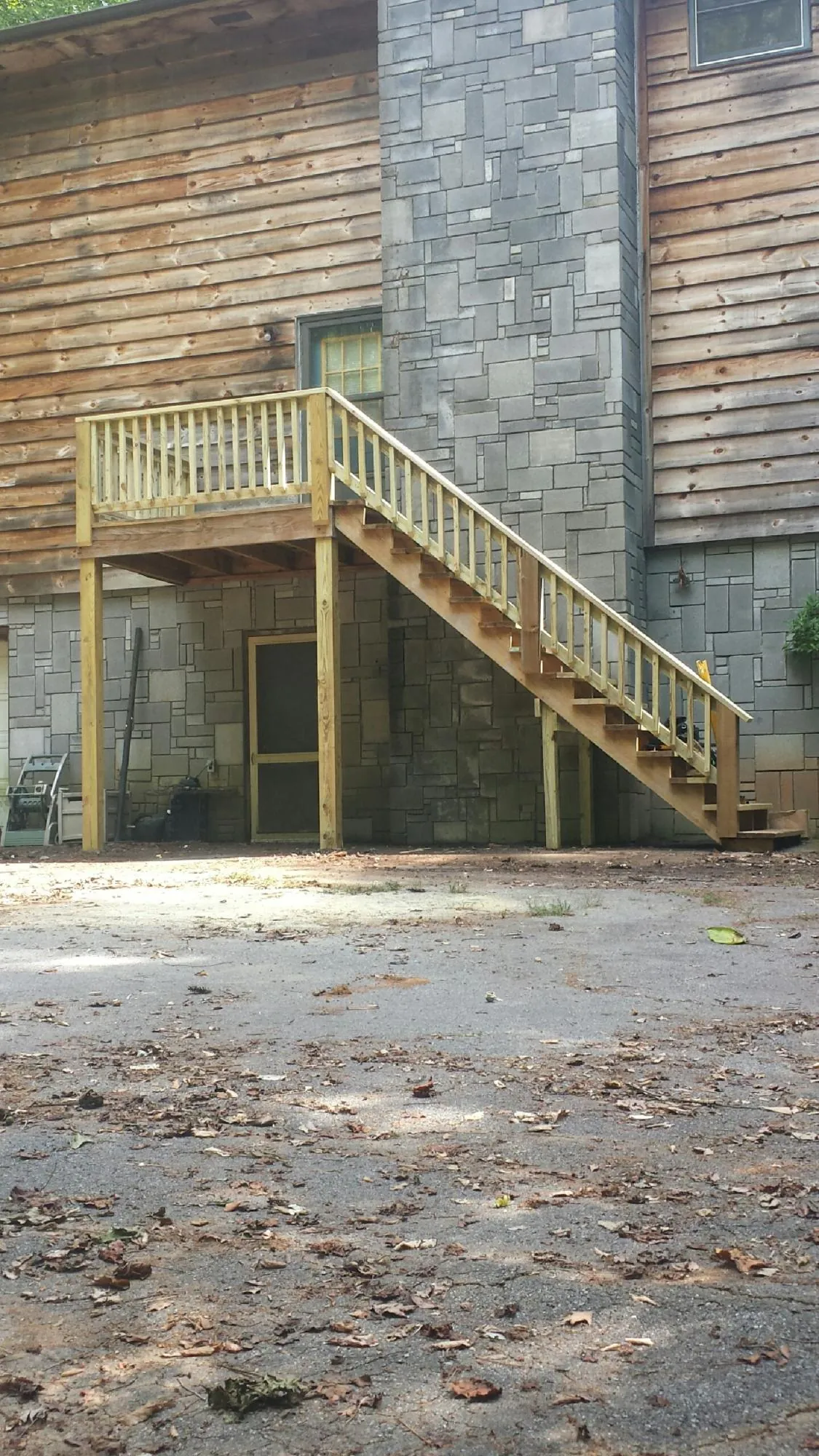 New pressure treated deck and stair landing on a log home in Medina